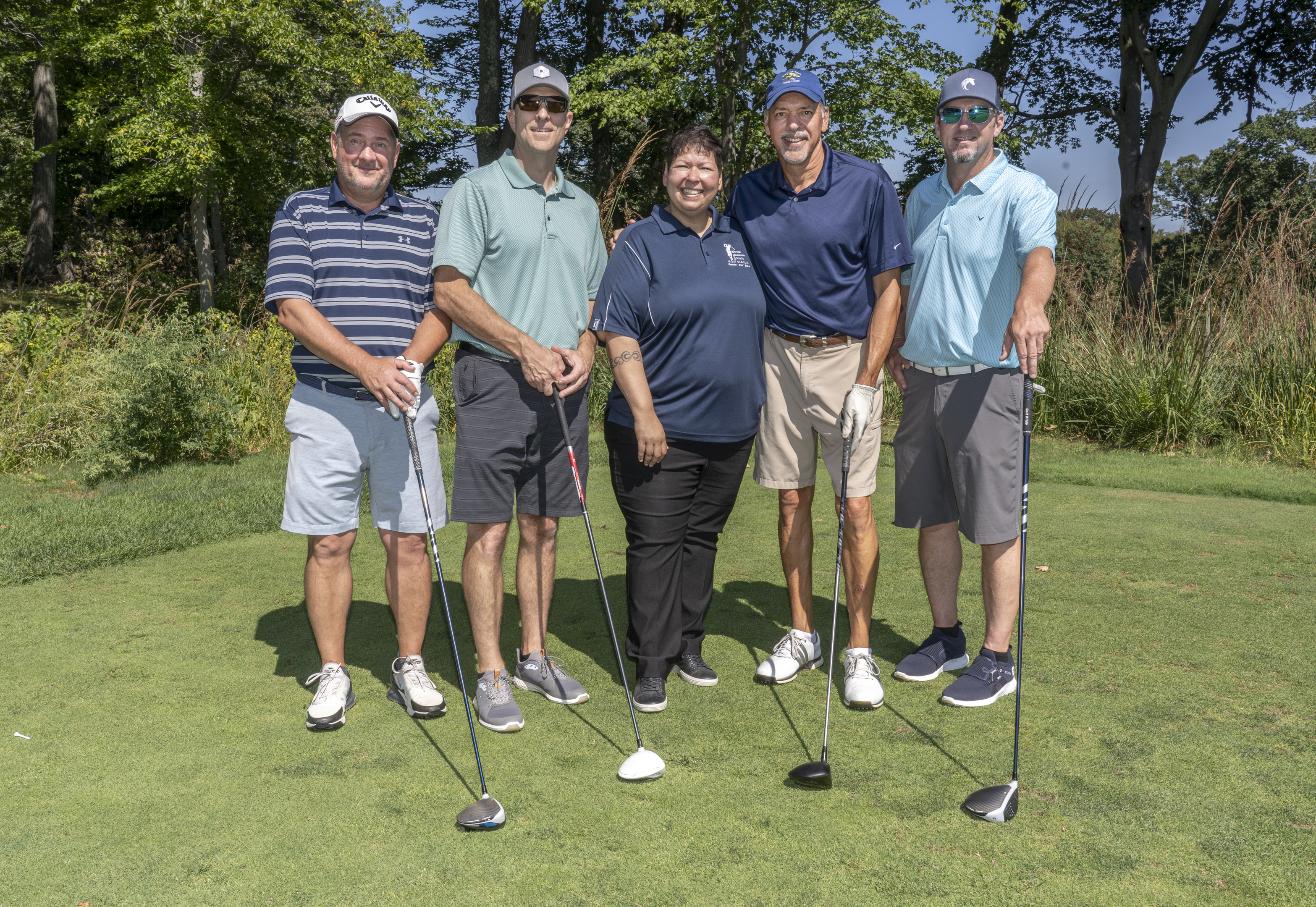 Christina Royal poses with golfers on a course